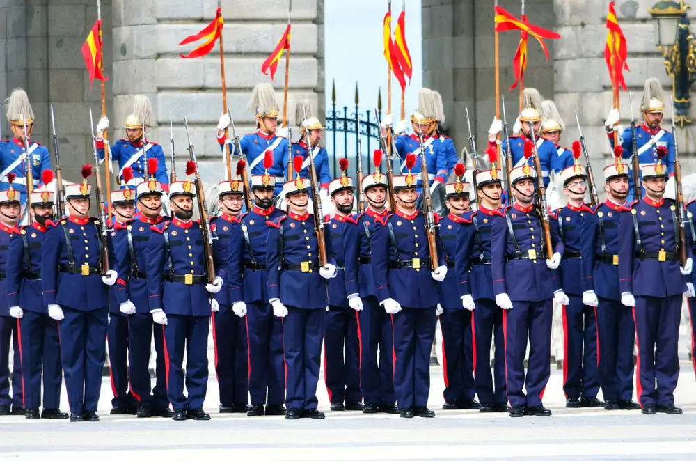 Soldados con uniforme de gala y fusiles en formación durante una ceremonia militar de jura de bandera.