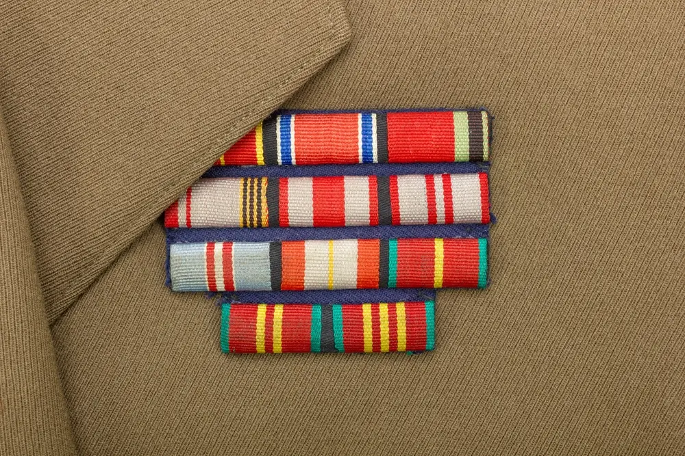 Detalle de insignias y galones militares en un uniforme, representando el rango y los méritos dentro de la academia.