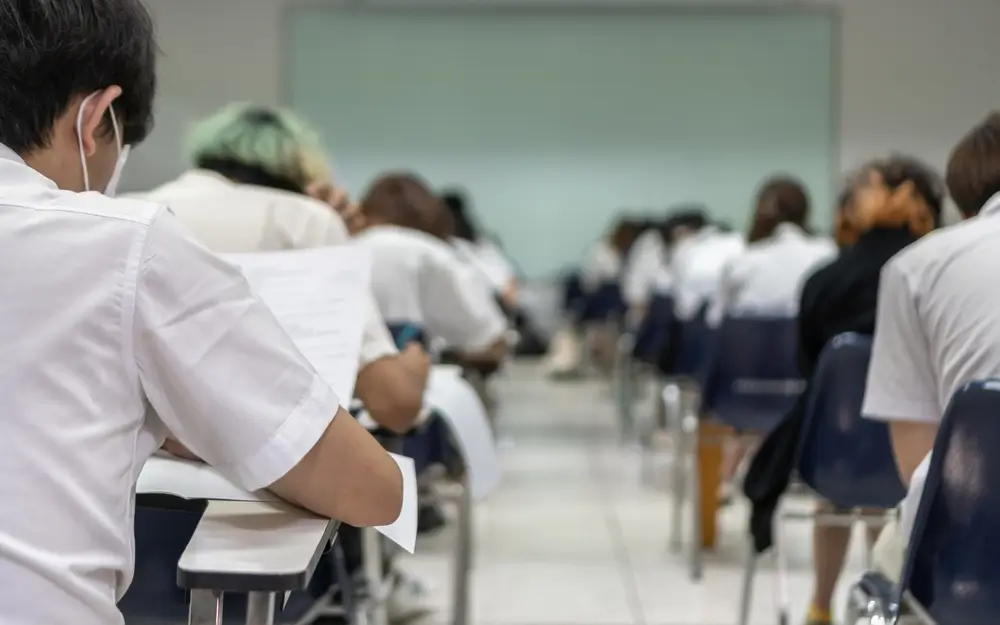 Opositores concentrados realizando exámenes escritos en un aula durante la fase de oposición de conocimientos.