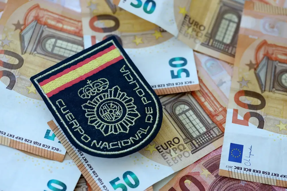 Insignia policial sobre billetes de 50 euros que representan el sueldo y la escala salarial de la Guardia Civil.