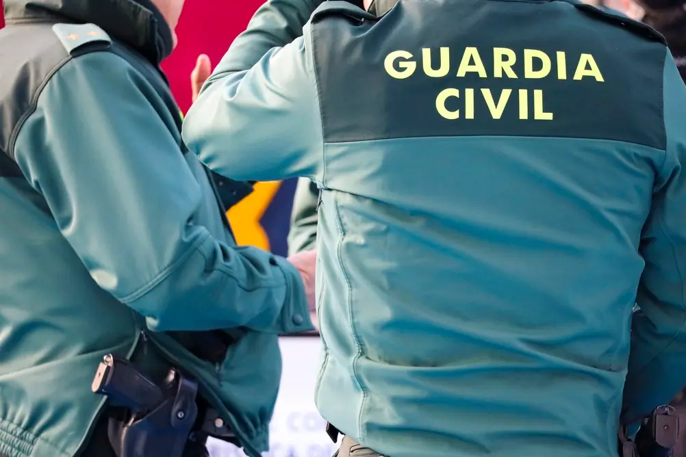 Agentes de la Guardia Civil de patrulla con el uniforme oficial en el que se lee el nombre del cuerpo.