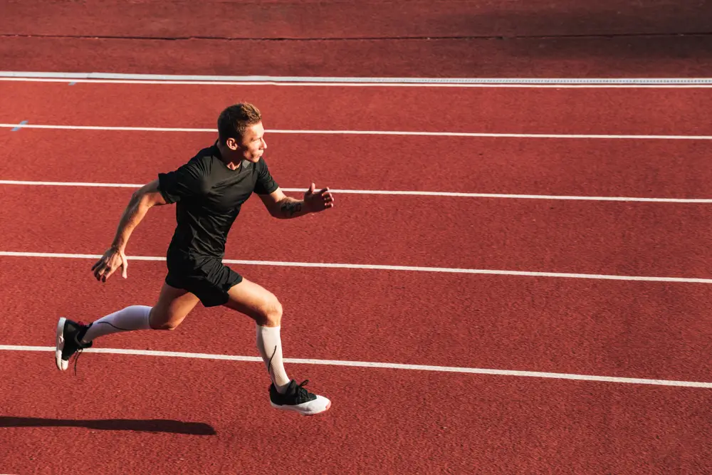 Opositor a la Guardia Civil corriendo en una pista de atletismo durante las pruebas físicas de acceso.