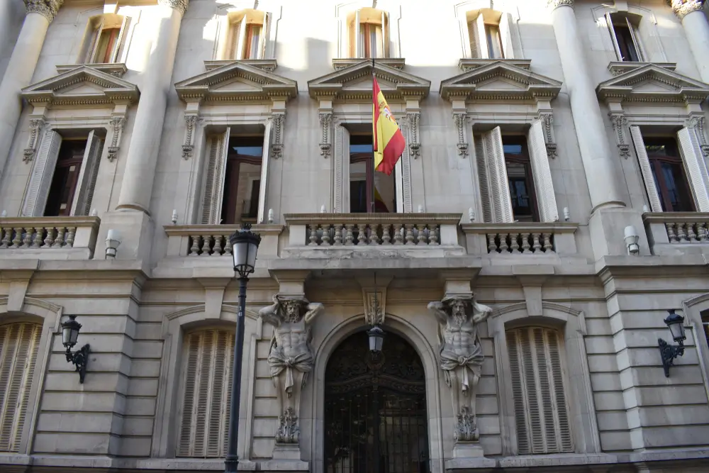 Fachada del edificio oficial de la academia de formación de la Guardia Civil con la bandera de España y esculturas.