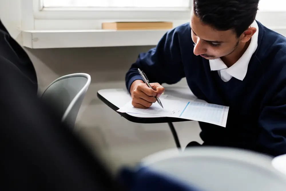 Opositor concentrado completando un examen tipo test de inglés para el acceso a la Guardia Civil en un aula.