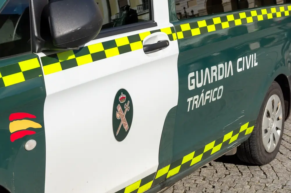 Coche patrulla de la Guardia Civil de Tráfico con el emblema oficial y franjas reflectantes de alta visibilidad.