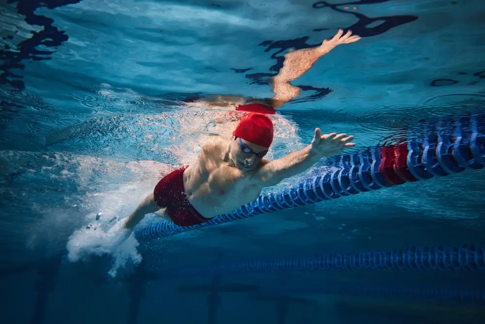 Nadador profesional entrenando natación estilo crol en una piscina de competición para la prueba de la Guardia Civil.