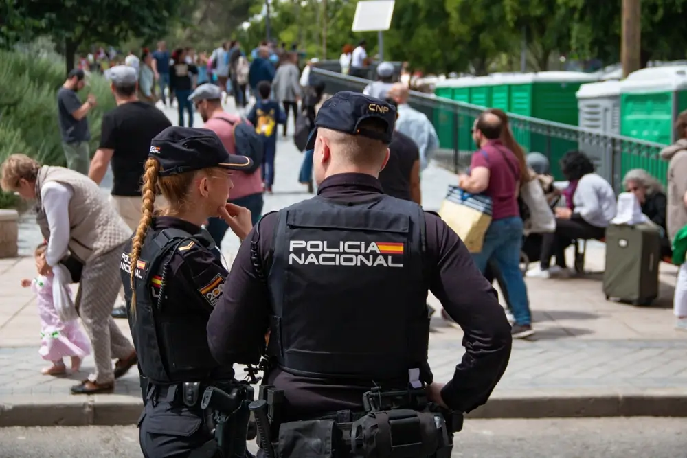 Dos agentes de la Policía Nacional patrullando una calle concurrida durante su servicio de vigilancia urbana.