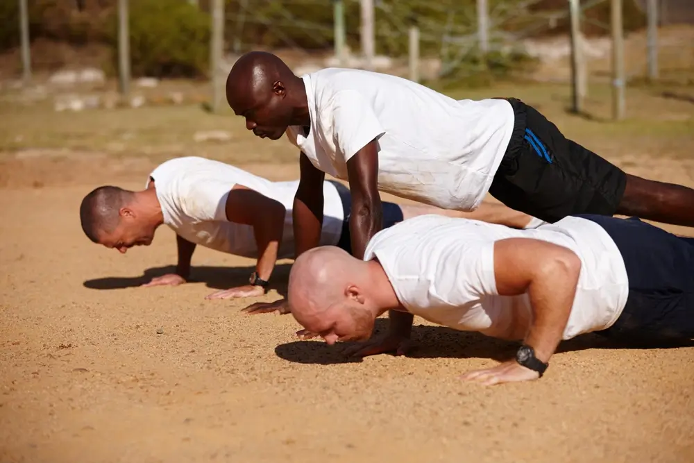 Aspirantes a la Guardia Civil realizando flexiones en el suelo durante su entrenamiento físico militar.