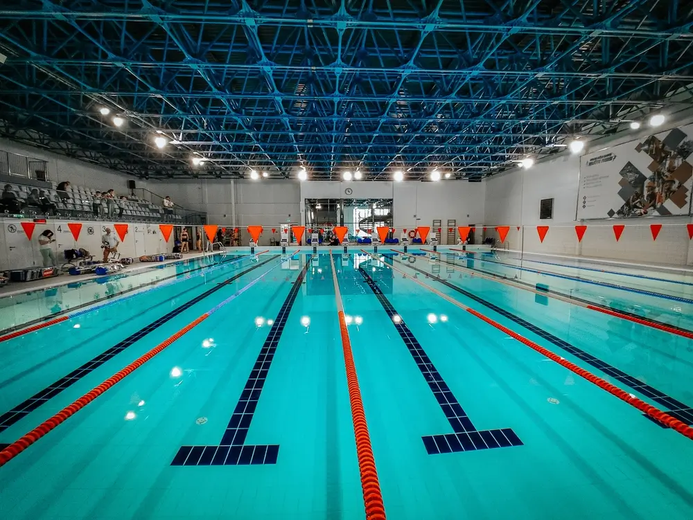 Piscina pública cubierta con calles delimitadas para entrenar técnica y velocidad en natación.