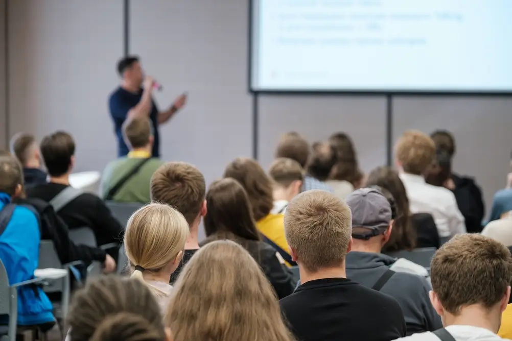 Aspirantes a la Guardia Civil de diversas estaturas atienden a una clase teórica en un aula de formación policial.