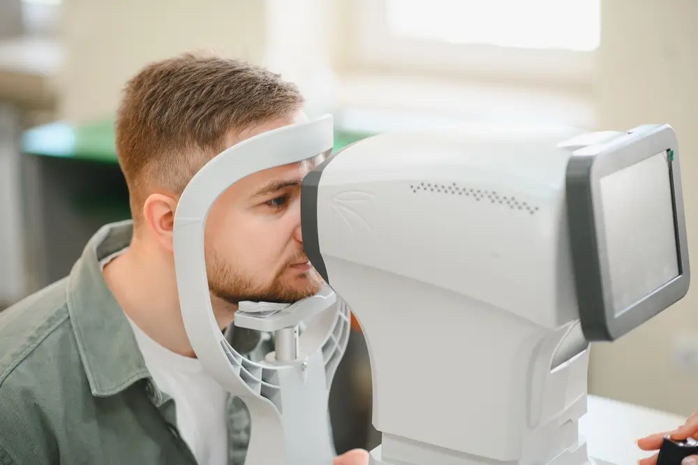 Aspirante realizando una prueba de visión y examen de la vista con un equipo especializado en un reconocimiento médico.