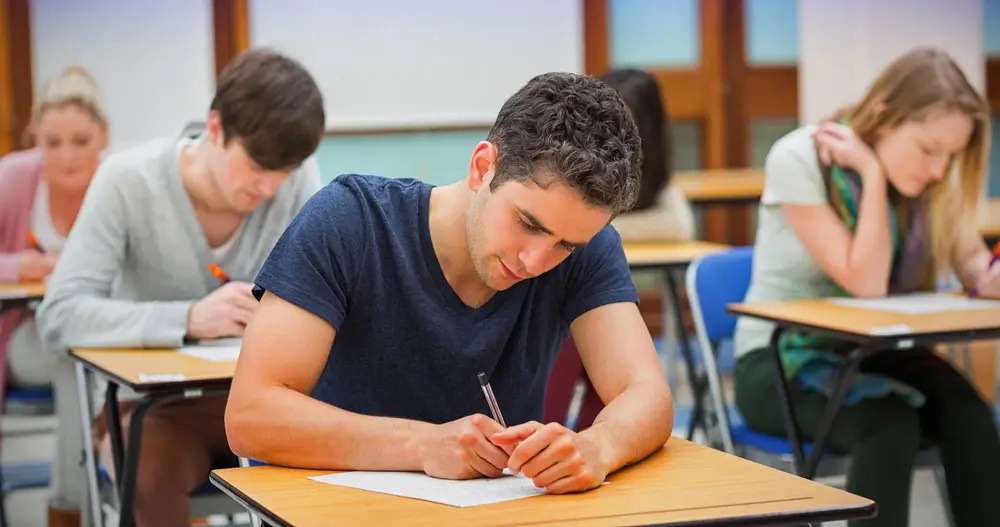 Aspirante a Guardia Civil concentrado durante las pruebas escritas de la oposición en un aula de examen.