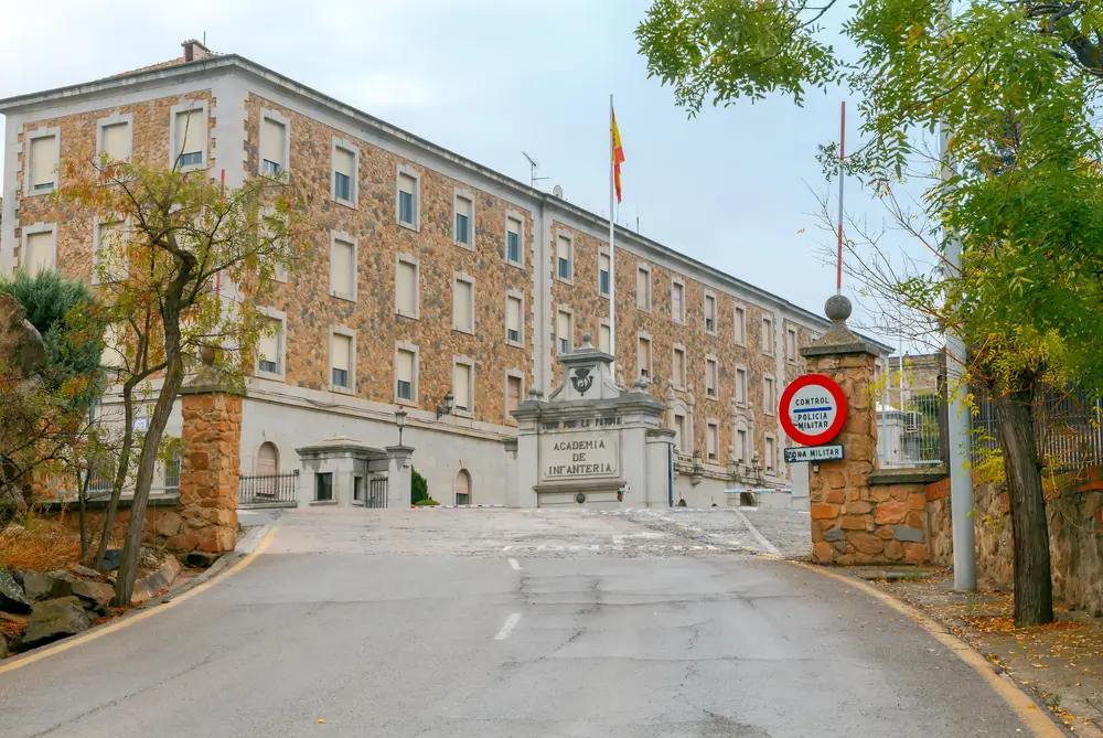 Fachada de la Academia de Oficiales de la Guardia Civil en Aranjuez con señal de policía militar y entrada de piedra.