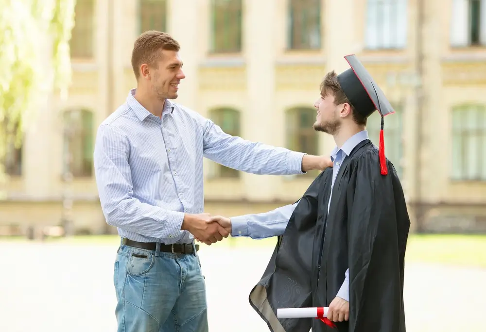 Un joven graduado estrecha la mano tras finalizar su formación en la academia de policía durante la entrega de títulos.