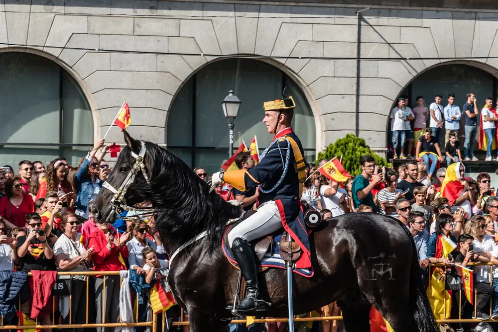 Agente de la Guardia Civil a caballo con el uniforme de gran gala durante un desfile oficial ante el público.